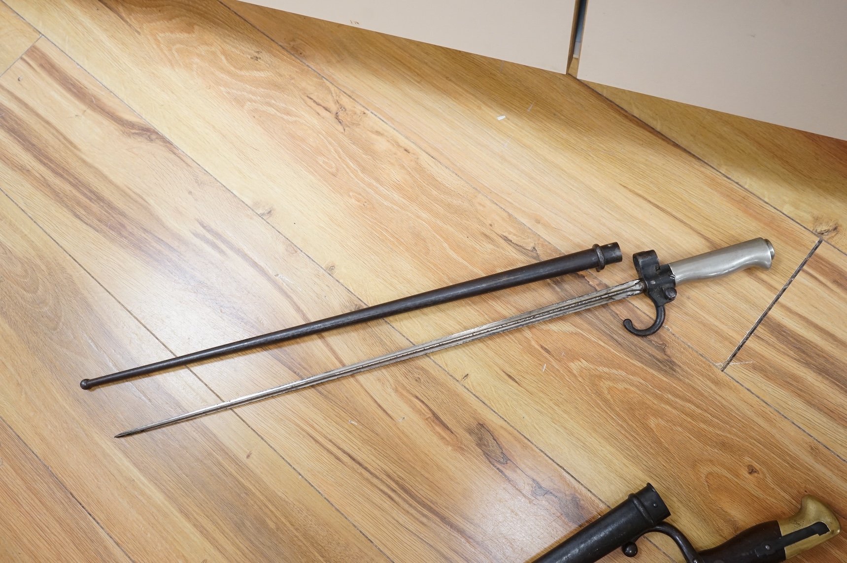 Three bayonets; a gras bayonet, a Lebel bayonet and an Indian Enfield style triangular socket bayonet, all in the original scabbards